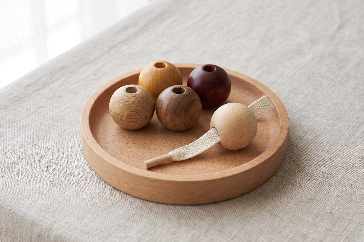 A small wooden tray on a table holding four large wooden beads and a short stiff lace with a wooden tip, one bead already threaded onto it.
