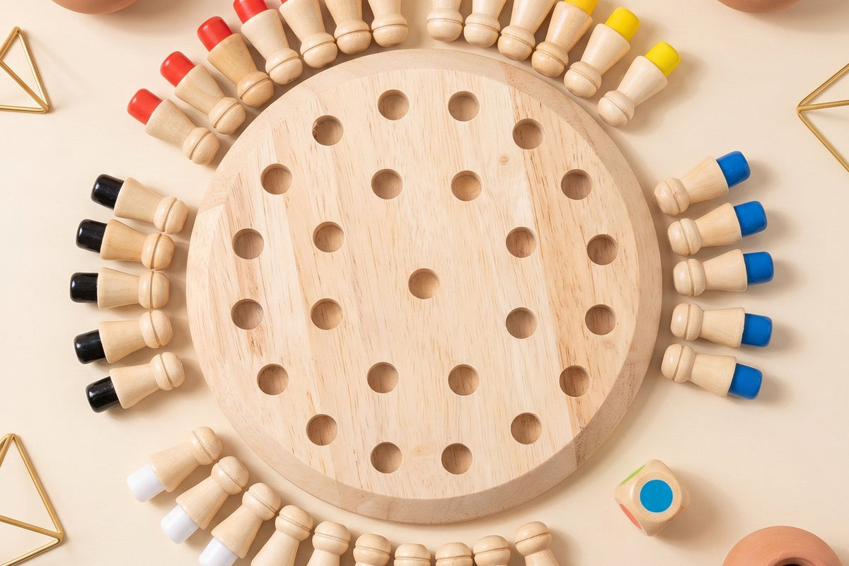 A round wooden color memory game seen from above, its wooden pegs laid in a ring around the board with their colored ends facing out, a wooden color die, small terracotta pots and gold wire shapes on a cream table.