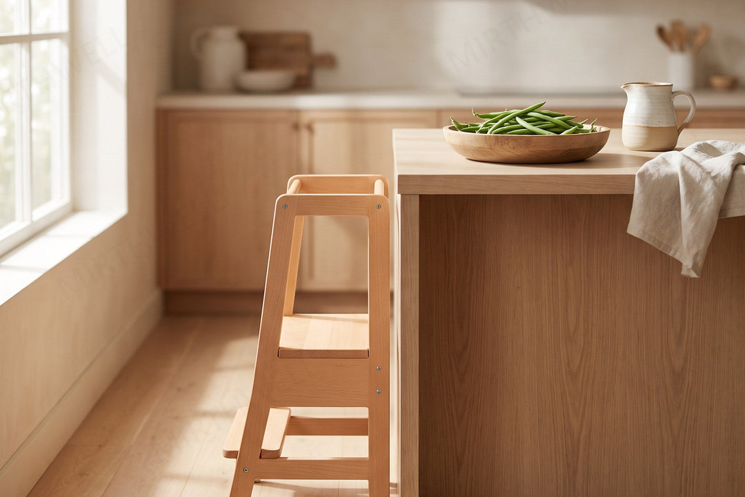 A wooden step stool with side rails standing at a kitchen counter, with a shallow bowl of green beans and a small ceramic jug on the counter above.