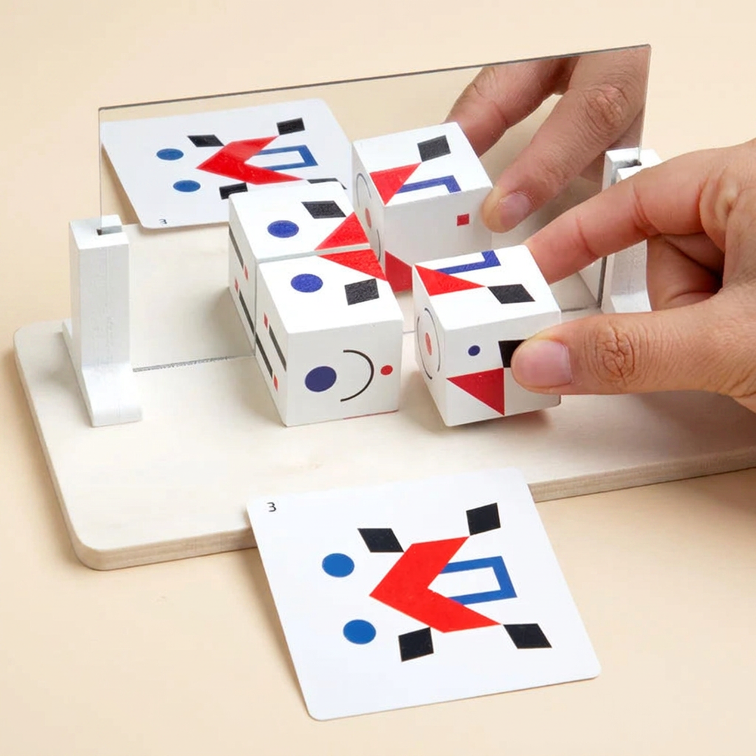 A hand placing a pattern cube against the mirror, the reflection completing the pattern