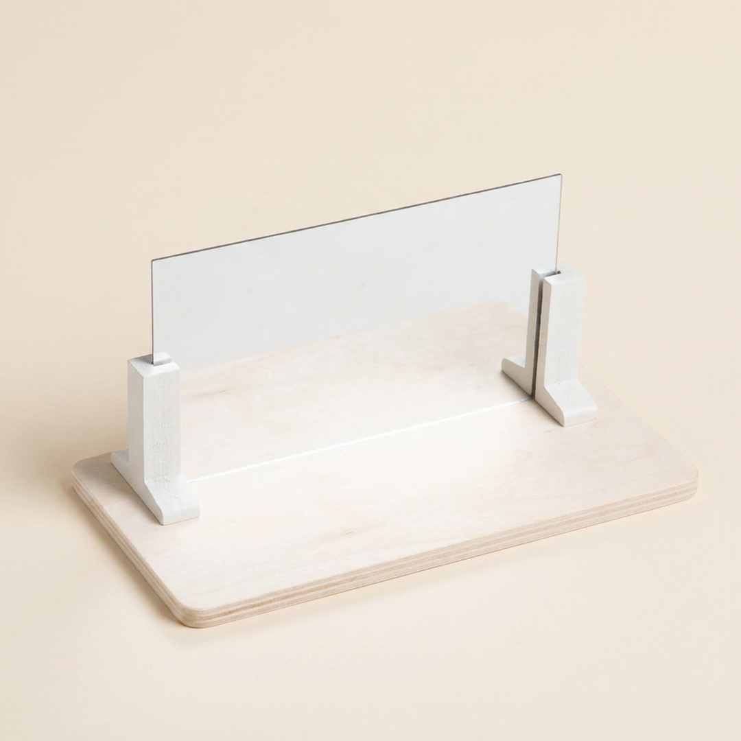 The wooden base with the acrylic mirror held upright by two white stand blocks