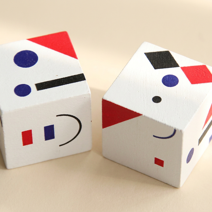 Close-up of two pattern cubes showing the printed red, blue and black shapes on their faces