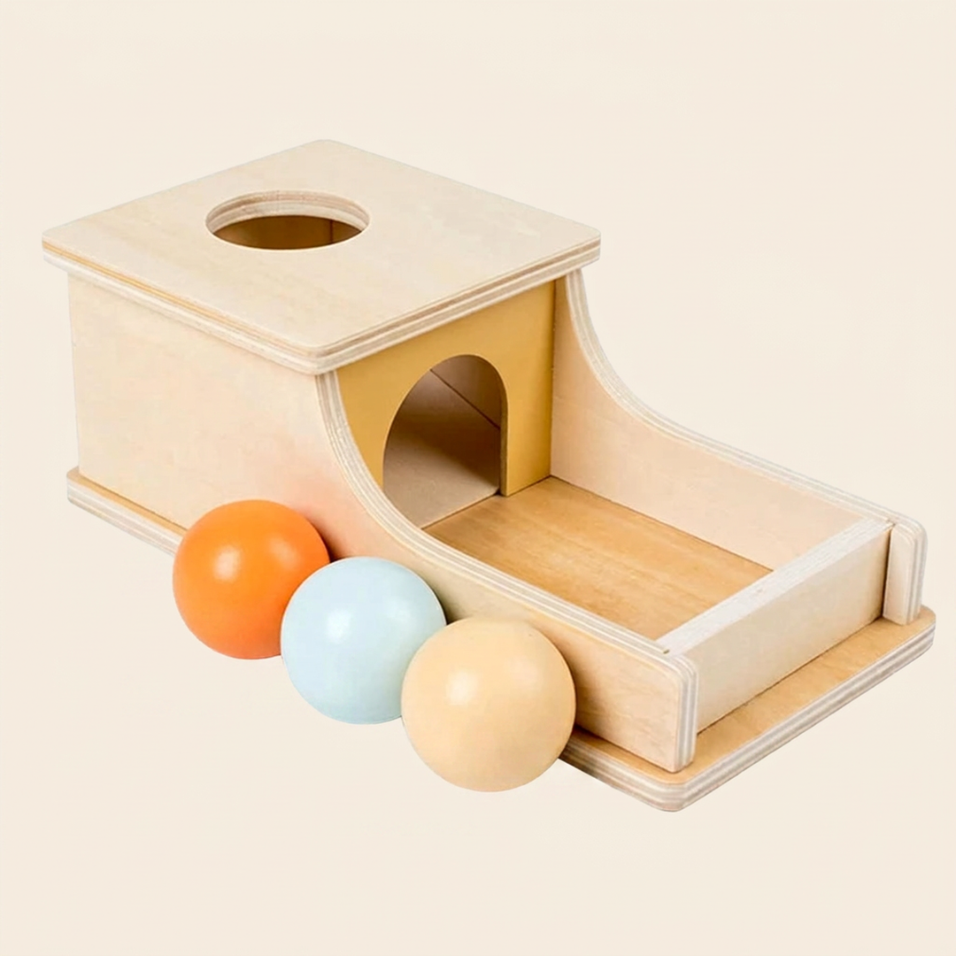 Birch-wood Montessori object permanence box on warm cream, with three solid-wood pastel balls - orange, mint and cream