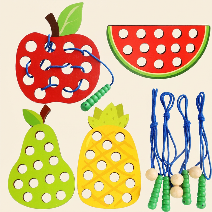 Wooden fruit lacing toy on warm cream - apple, pear, watermelon and pineapple boards with green worm laces
