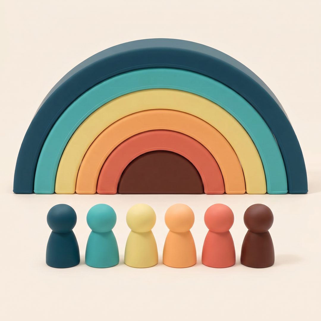 Silicone rainbow stacker on warm cream - six nested arches stacked into a rainbow with six matching peg dolls