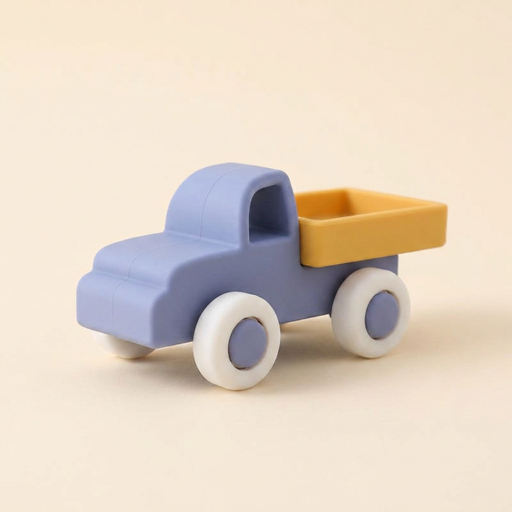 Soft silicone toy lorry on warm cream - powder-blue cab, mustard tray and soft rolling wheels