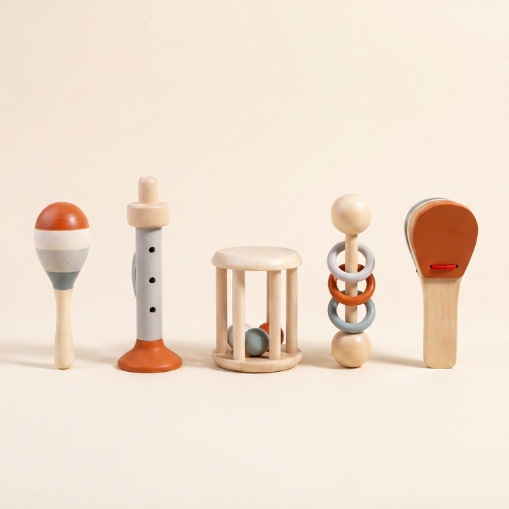 All five wooden instruments laid out in a row - horn, roller drum, clapper spoon, maraca and ring rattle