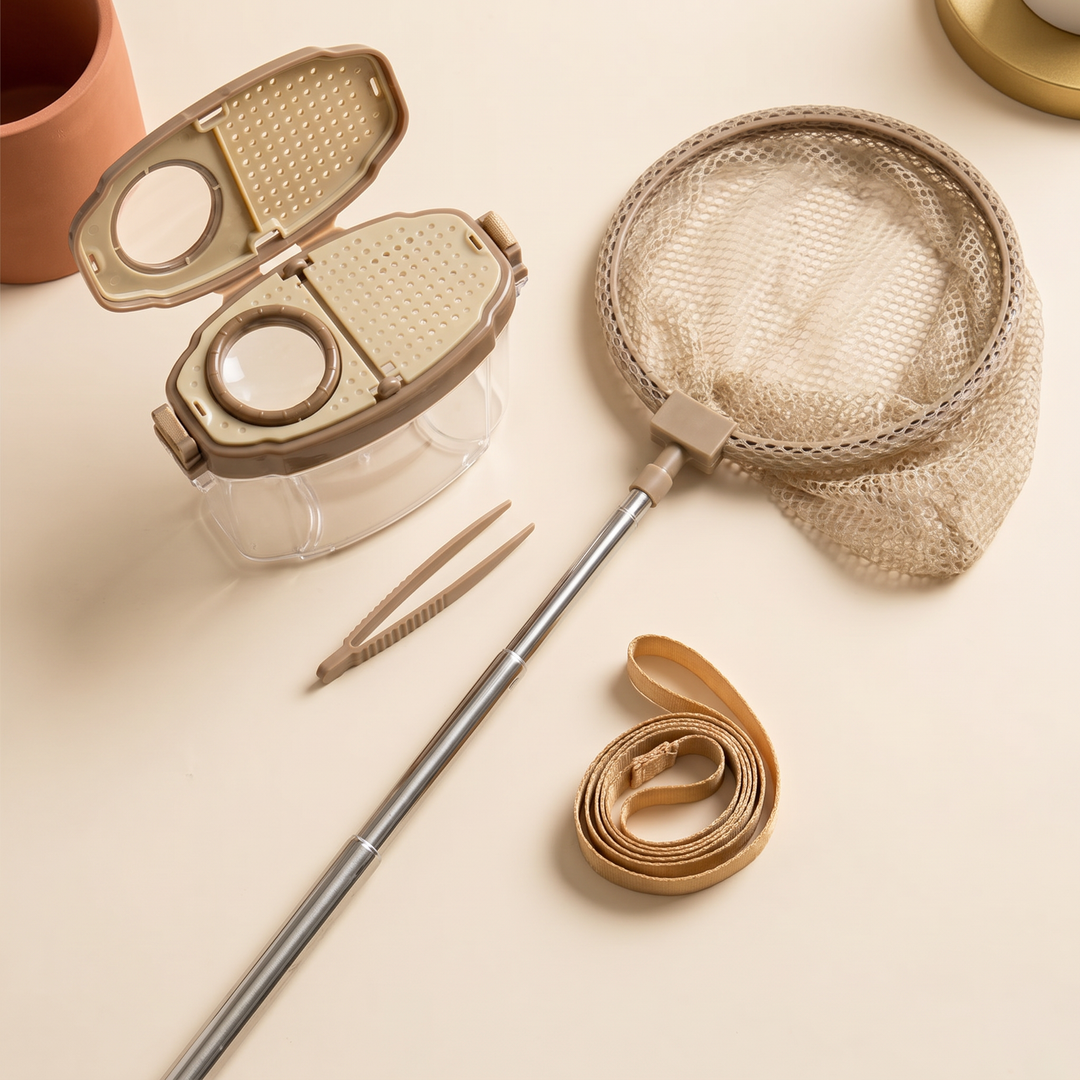 The insect kit laid out flat - clear box, magnifier lid, extended net, tweezers and strap