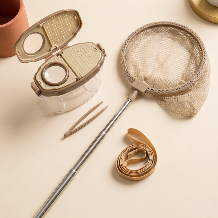 The insect kit laid out flat - clear box, magnifier lid, extended net, tweezers and strap
