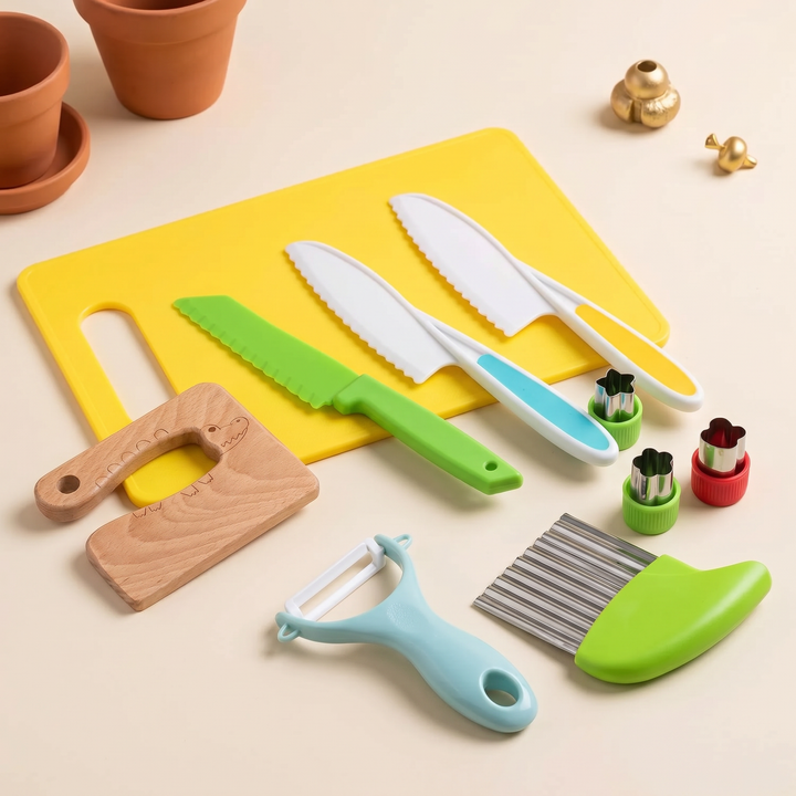 The full kids cooking set fanned out - colored-grip safe knives, beechwood knife, peeler, cutters and board