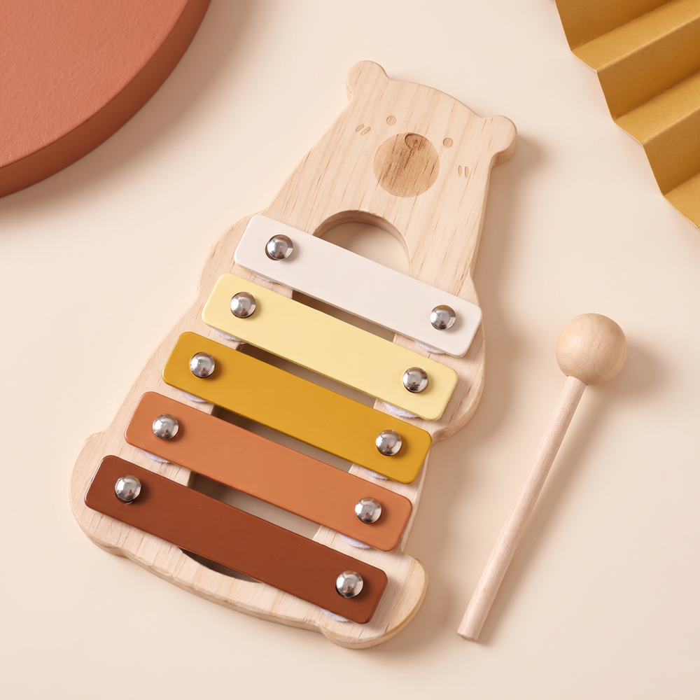 Bear xylophone from an angle showing the carved bear face and five stepped colour bars
