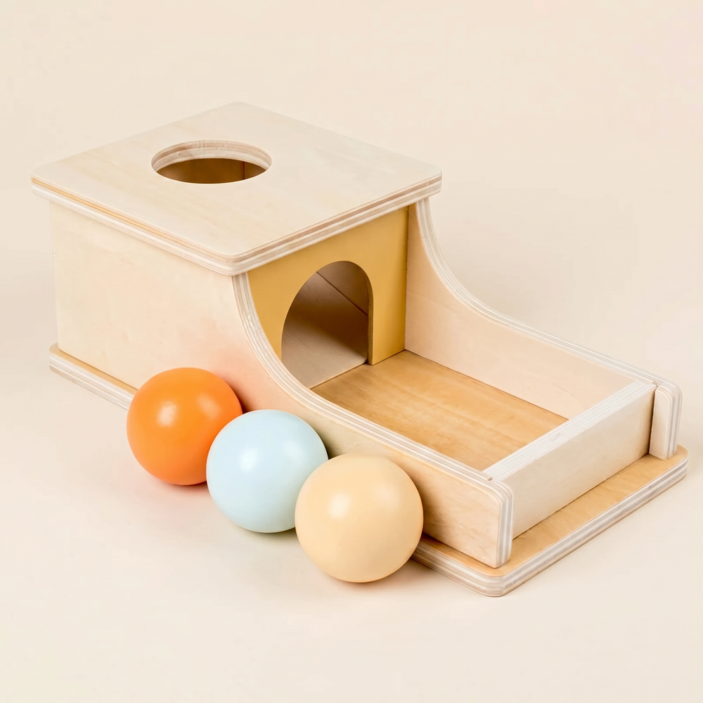 Wooden object permanence box from above showing the top drop-hole and the curved front ramp to the tray