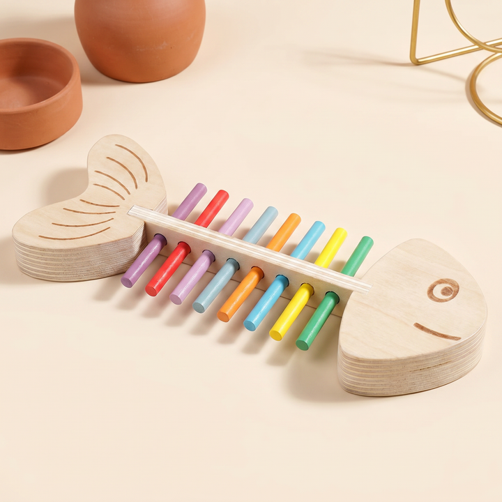 Three-quarter view of the assembled wooden fish-skeleton toy with rainbow colored sticks