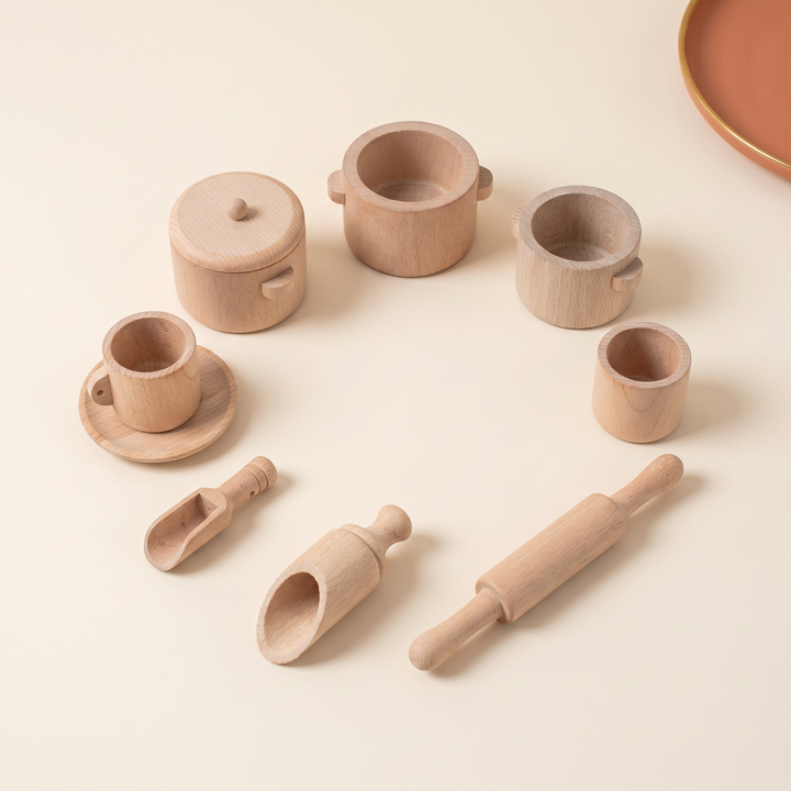 Full wooden tea and kitchen set arranged in a neat circle on warm cream
