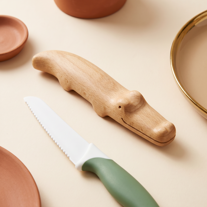 Close-up of the beechwood crocodile knife and a serrated nylon safe knife with rounded edges