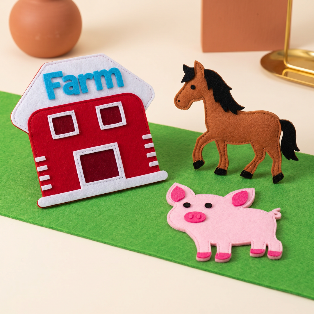 Close-up of felt farm figures - the red barn, a horse and a pig - on the soft green felt board