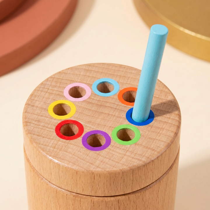 Close-up of the color-ringed holes on the canister lid with a matching rainbow stick resting in place