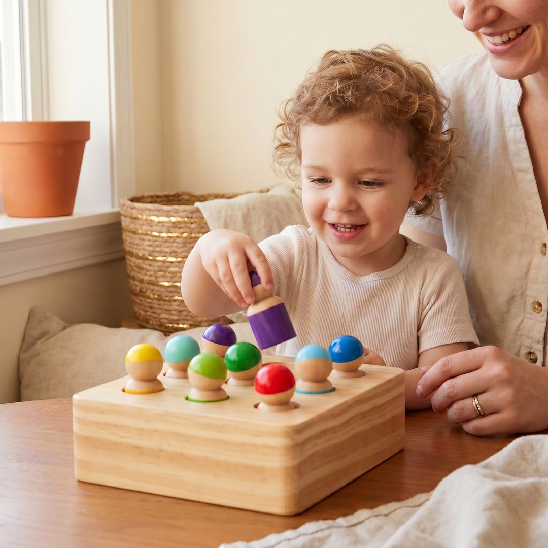A young child placing a colored wooden peg person into a socket on the board