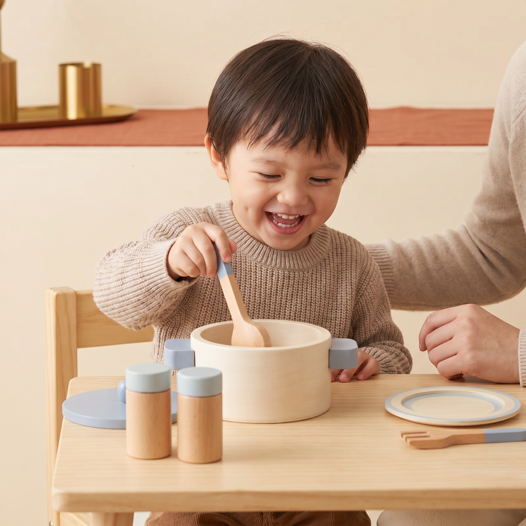 A young child happily cooking with the wooden pot and ladle