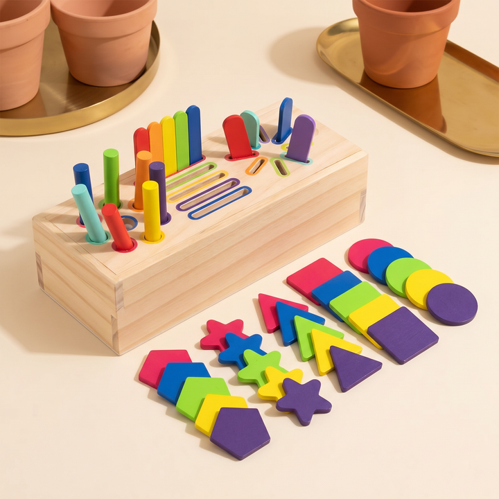Assembled wooden sorting box with rainbow pegs and sticks in their slots and shape tiles beside it