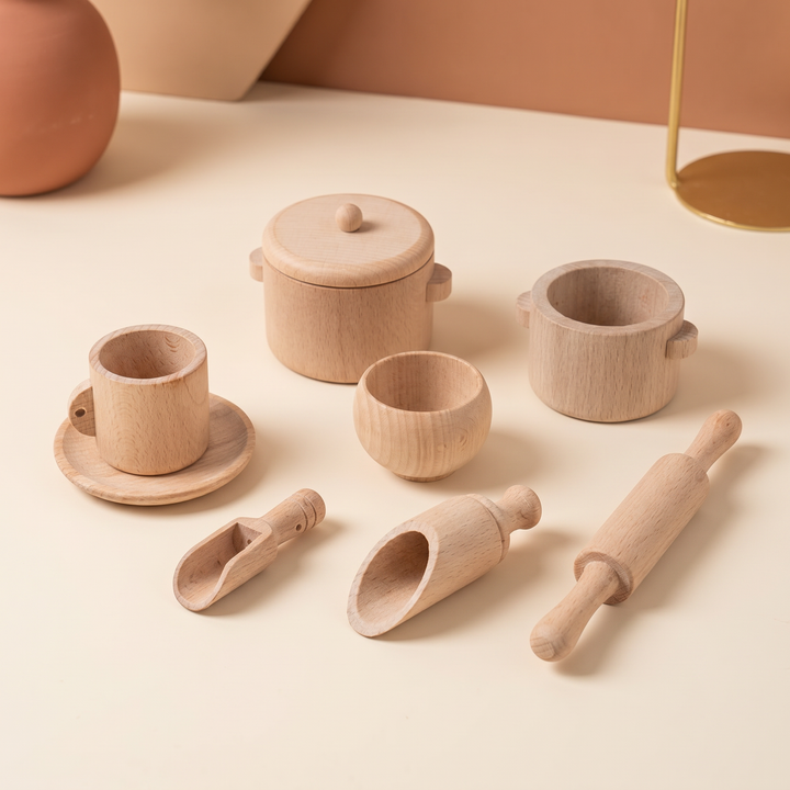 The nine-piece wooden tea and kitchen play set laid out neatly on warm cream