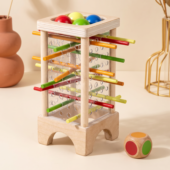 Assembled wooden stick-drop tower with rainbow sticks, balls on top and the color dice